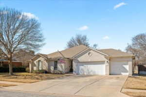 Daytime street view of the single-story brick assisted living home in Round Rock, TX with an attached two-car garage