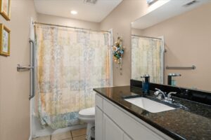 Accessible bathroom with a walk-in shower-tub, safety grab bars, and a granite-topped vanity