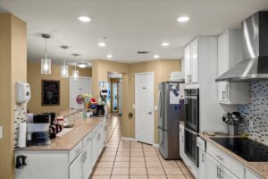 Spacious kitchen with a central island, white cabinets, and stainless steel appliances