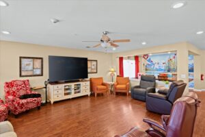 Common living room with cozy seating, recliners, and a wall-mounted TV