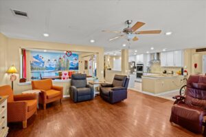 Living area with recliners, wood-look flooring, and a scenic wall mural