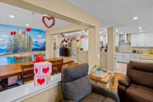 Shared living and dining space with lounge seating and a lake mural